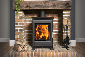 Portway Luxima Deluxe 5kW Wood Burning Stove with flames in a brick fireplace suite