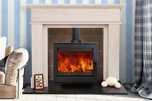 Woodford - Pankhurst Large 8kW Eco Design Wood Burning Stove in a white fireplace suite